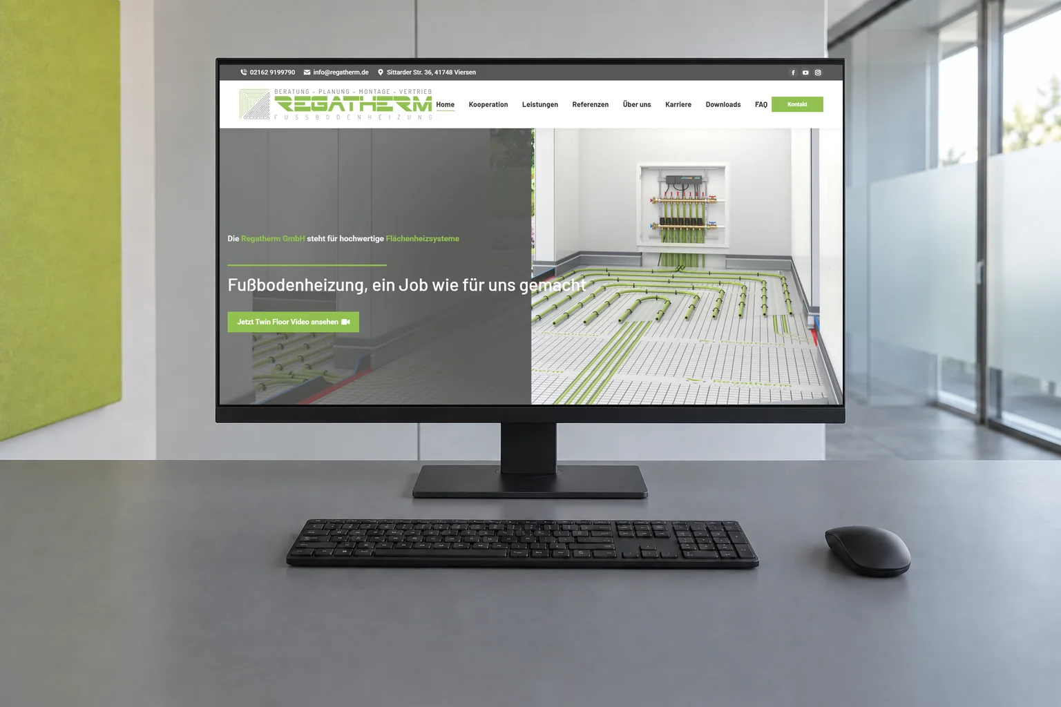 Regatherm-Startseite mit Fußbodenheizung und Heizungsverteiler auf einem Desktopmonitor, davor Tastatur und Maus