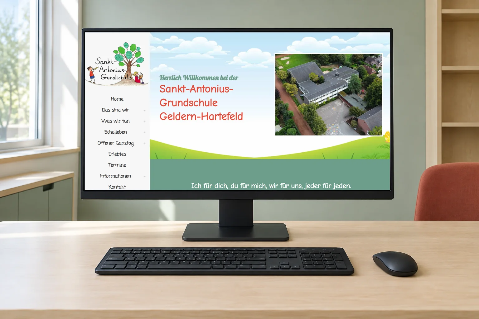 Startseite der Sankt-Antonius-Grundschule Geldern-Hartefeld mit Luftaufnahme der Schule auf einem Desktopmonitor