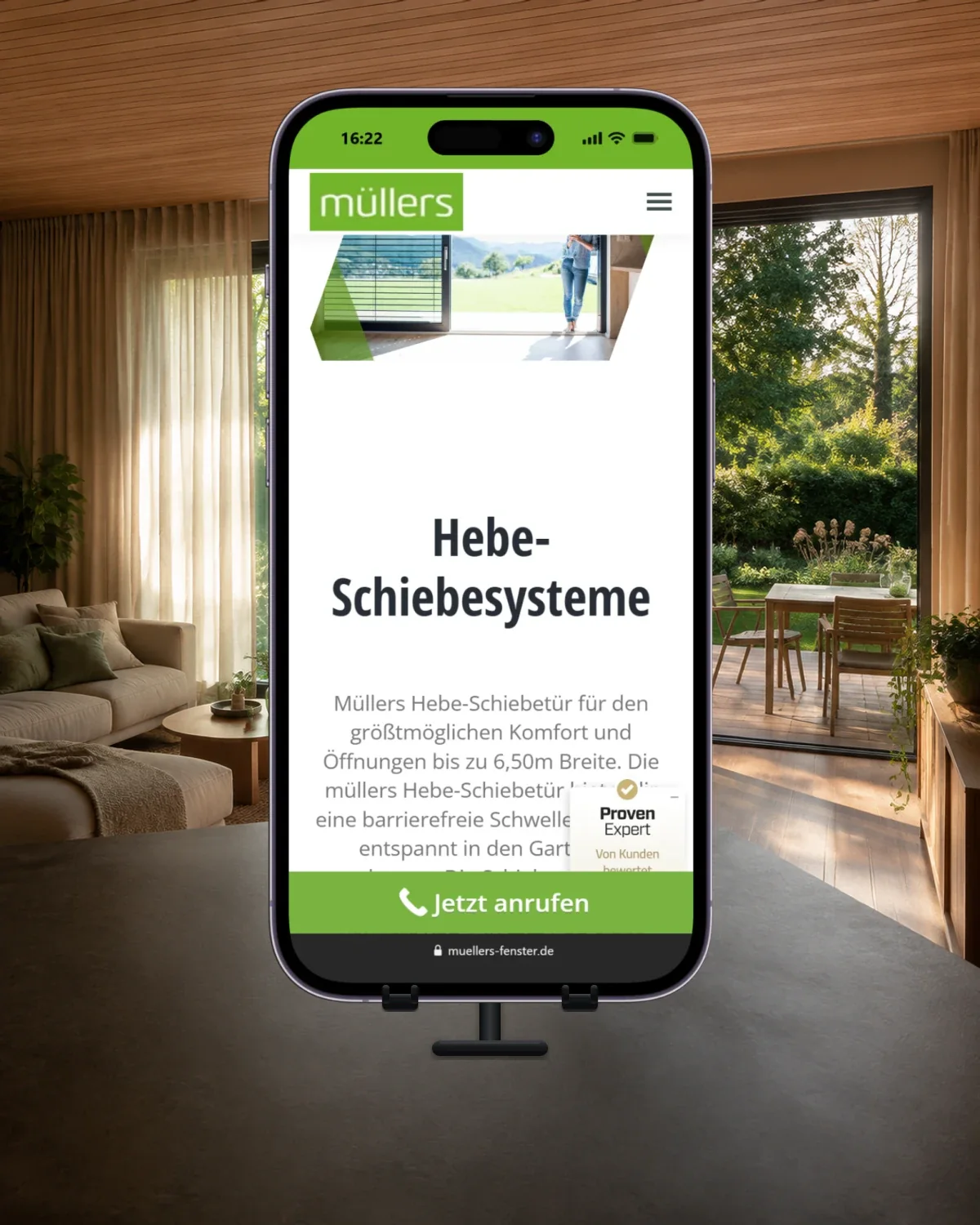 Smartphone auf einem Tischständer vor einer geöffneten Terrassentür; angezeigt wird die Müllers-Seite zu Hebe-Schiebesystemen.