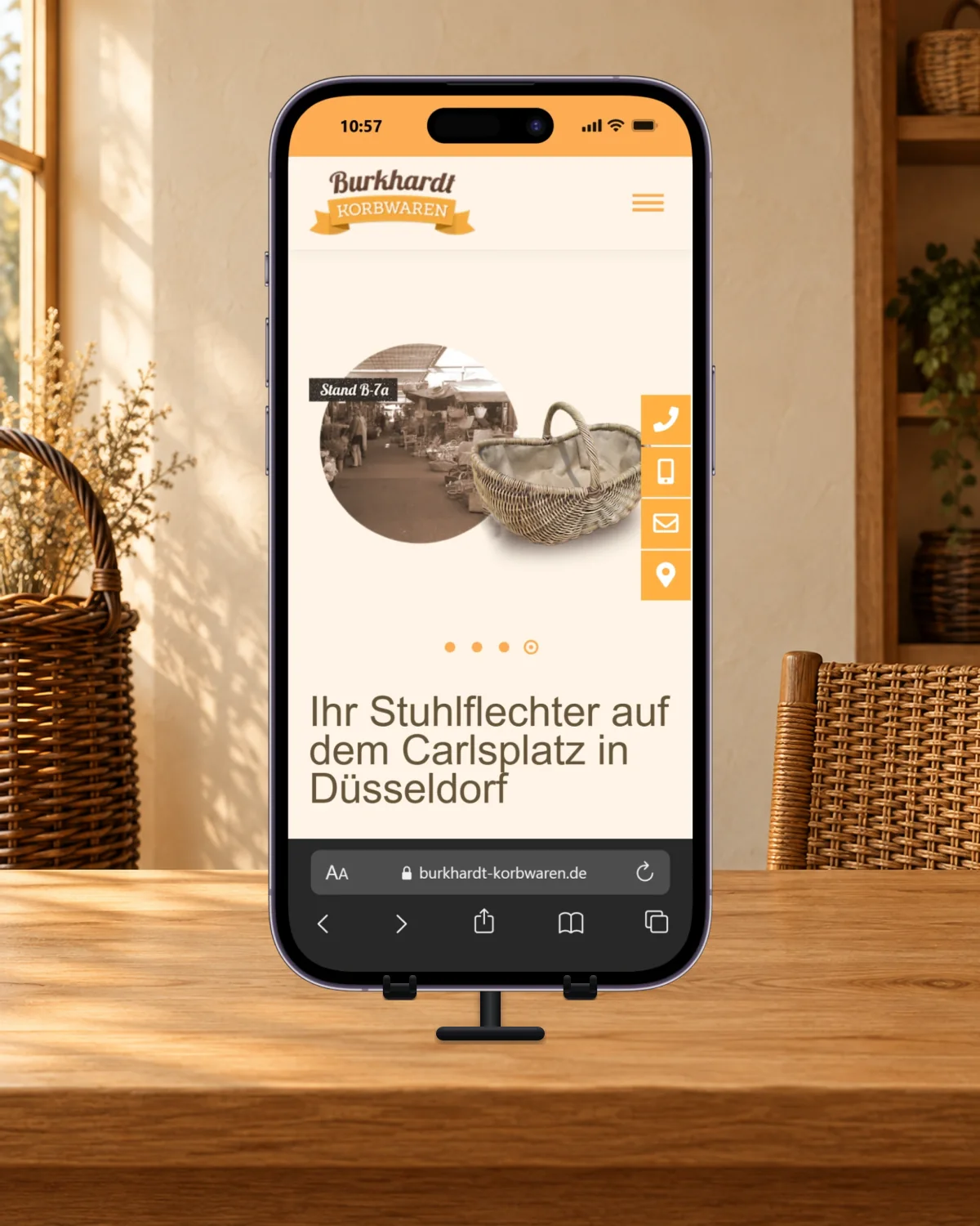 iPhone mit der mobilen Burkhardt-Startseite, Marktstand und Korbmotiv in einer warmen Korbwarenumgebung